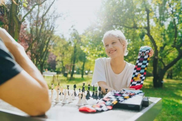 Skarpetki szachowe Rainbow Socks 47-50 – 2 pary w pudełku. Skarpetki i otwarte pudełko przy szachownicy.